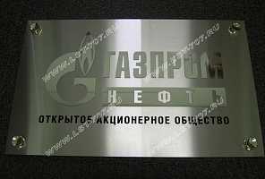 Металлическая табличка из нержавеющей стали с логотипом ПАО «Газпром-нефть», выполненным из зеркальной нержавейки под серебро и заливкой текста черной эмалью.